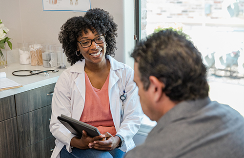 Female medical provider speaks with male patient