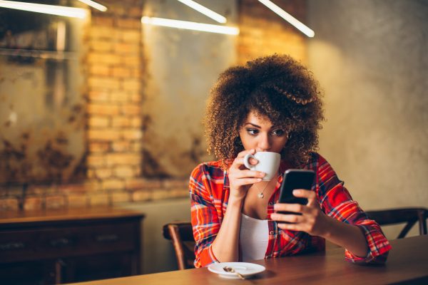 CompHealth - tax tips for locum tenens physicians - image of locum tenens provider in a coffee shop tracking expenses on her mobile device