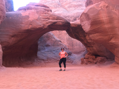 Woman in front of natural arch