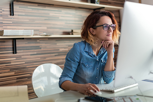 Physician on laptop researching locum tenens agencies