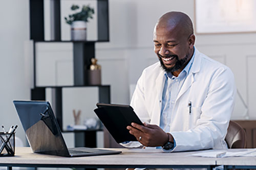 Man looking at a tablet and smiling.